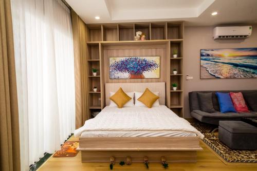 a bedroom with a large bed and a couch at Căn hộ TMS Pullman cao cấp Studio có ban công view biển - Golden Wave Homestay in Quy Nhon
