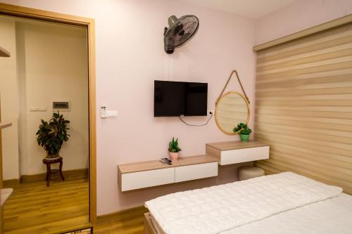 a bedroom with a bed and a tv on the wall at Căn hộ TMS Pullman cao cấp Studio có ban công view biển - Golden Wave Homestay in Quy Nhon