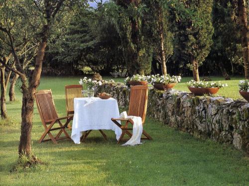 a table and three chairs with a table and flowers at Casona de San Pantaleón de Aras in San Pantaleón de Aras