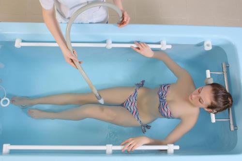a woman in a swimming pool with a hoop at Hotel Termal in Baile Felix