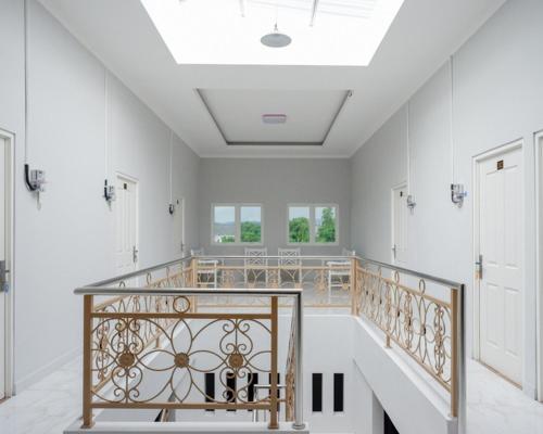 - un escalier dans une maison aux murs blancs et au plafond dans l'établissement RedDoorz @ City Park Medoho Semarang, à Alastuwo