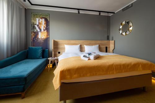 - une chambre avec un lit et un canapé bleu dans l'établissement The Rilano Hotel Stuttgart Böblingen, à Böblingen