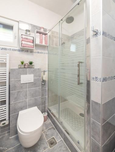 a bathroom with a toilet and a glass shower at Apartments Neppa in Postira