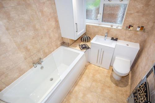 a bathroom with a tub and a toilet and a sink at Snowdrop Cottage nr Alton Towers & Peak District, Sleeps 4+2 in Cauldon