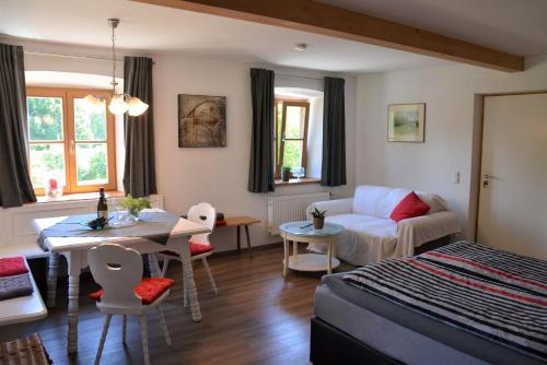 1 dormitorio con cama, mesa y sofá en Kötzing am Golfplatz, en Chieming