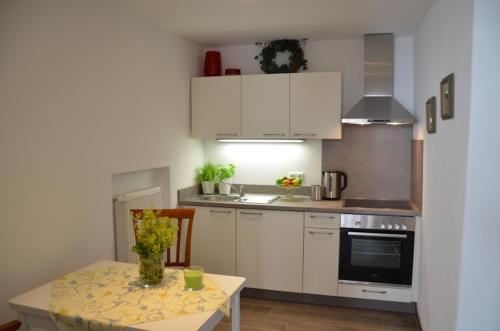 a kitchen with white cabinets and a table with a table sidx sidx sidx at Kötzing am Golfplatz in Chieming