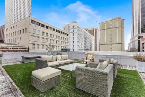 a rooftop patio with wicker chairs and a table at City View Condo with Private Rooftop in New Orleans