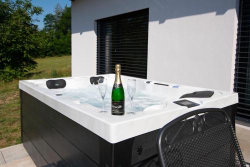 eine Badewanne mit einer Flasche Champagner und zwei Weingläsern in der Unterkunft Wellness bungalov - vodní nádrž Slapy - 40km od Prahy in Nečín