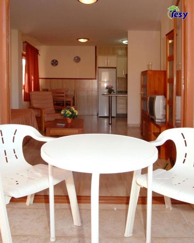 a white table and two chairs in a living room at Apartamentos Tesy in La Manga del Mar Menor
