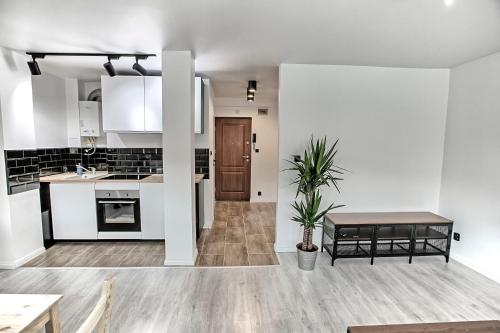 una cocina con armarios blancos y una mesa. en Apartament Akademia, en Legnica