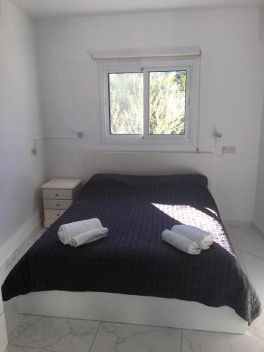 a bedroom with a bed with two towels on it at Jacks Apartment in Paphos City