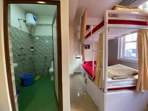 a bathroom with a toilet, sink, and shower stall at Tag Along Backpackers in Gangtok