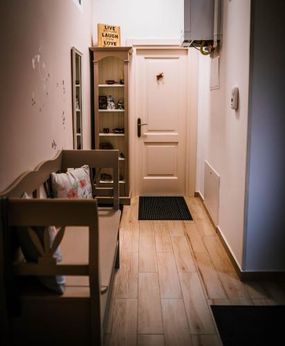 a hallway with a white door and a wooden floor at Brassai Square in Braşov