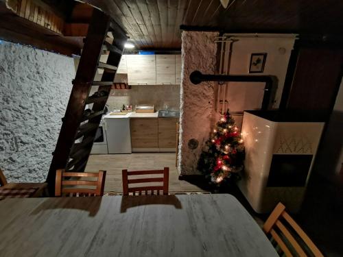 a christmas tree in a kitchen with a table at Winter house Vlasic in Šišava