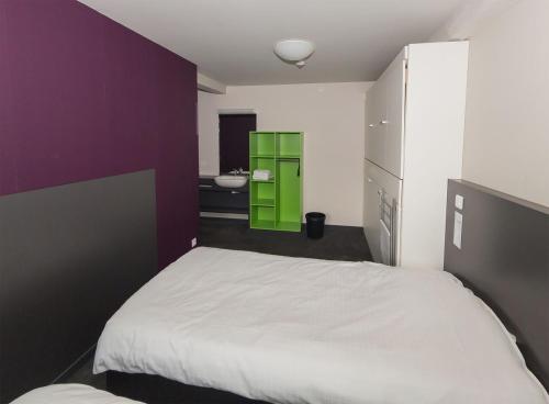 a bedroom with a white bed and a green cabinet at Focus Budget in Kortrijk