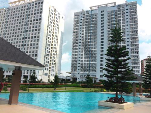 a swimming pool with a christmas tree in front of two tall buildings at Wind and Sea at Wind Residences in Tagaytay