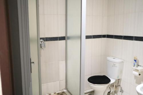 a bathroom with a toilet with a black seat at KwaZikode Bed & Breakfast in Meyerton