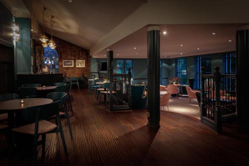 a restaurant with tables and chairs in a room at Mercure Blackburn Dunkenhalgh Hotel & Spa in Blackburn