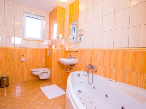 uma casa de banho com uma banheira, um WC e um lavatório. em Hotel Trend em Plzeň