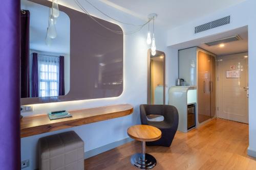 a room with a desk and a chair and a mirror at Puding Hotel in Antalya