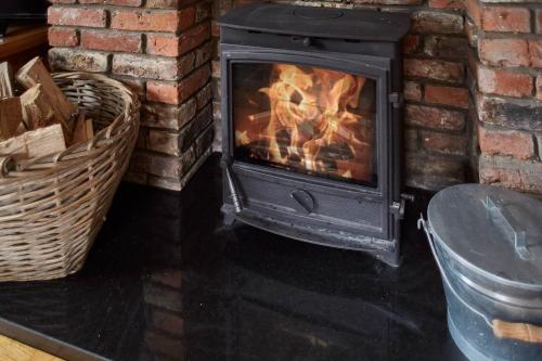a fireplace in a room with a brick wall at Host & Stay - Great Habton Cottage in Malton