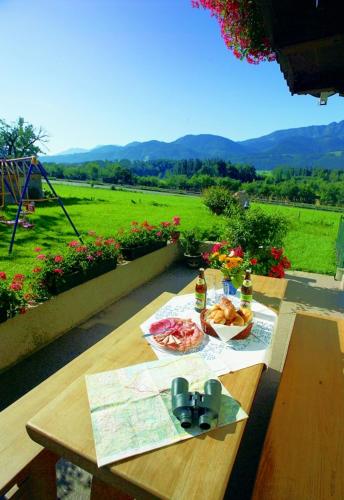 a picnic table with food and a view of a field at Beim Most`l in Grabenstätt