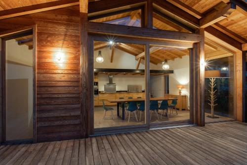 a dining room and living room with sliding glass doors at CHALET ALTAÏ in Séez