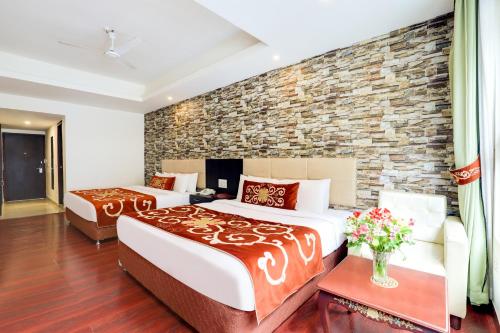 a bedroom with two beds and a brick wall at The Fern Denzong Hotel & Spa Gangtok, Sikkim in Gangtok