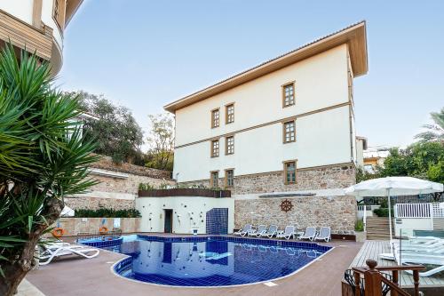 een hotel met een zwembad voor een gebouw bij Puding Hotel in Antalya