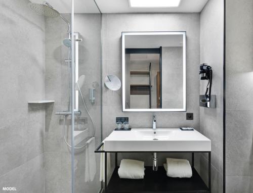 a bathroom with a sink and a mirror and a shower at Riu Plaza Manhattan Times Square in New York