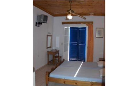 a room with a bed and a blue door at Theodora Studios in Yenion