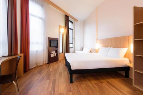 um quarto de hotel com uma cama e uma televisão em Ibis Bilbao Centro em Bilbao