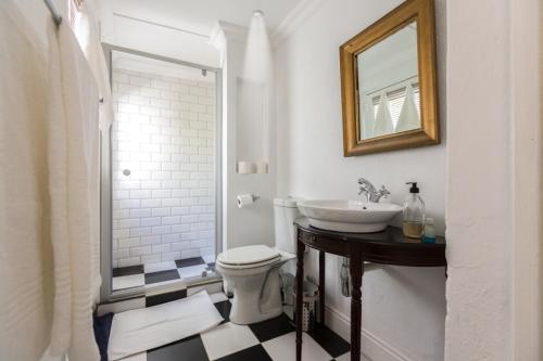 ein Badezimmer mit einem Waschbecken, einem WC und einem Spiegel in der Unterkunft Green Elephant Backpackers in Kapstadt