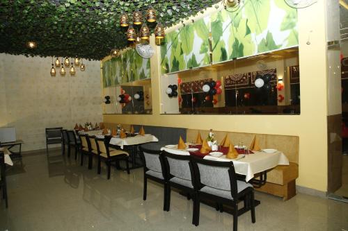 un comedor con mesas y sillas en un restaurante en Hotel Manas Plus, en Khandwa