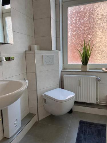 a bathroom with a toilet and a sink and a window at City Apartment Bremerhaven in Bremerhaven