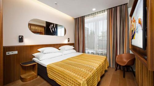 a hotel room with a bed and a television at Hestia Hotel Kentmanni in Tallinn