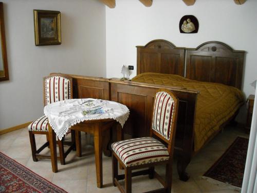 モーリにあるLa Cort Di Nonna Rosaのベッドルーム1室(ベッド1台、テーブル、椅子付)