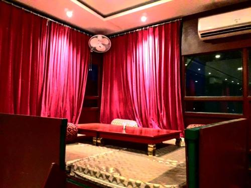 a living room with red curtains and a red couch at Hotel Mewari Villa PURE VEG in Udaipur