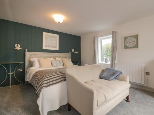 een slaapkamer met een bed en een stoel bij Crantock Lodge in Newquay