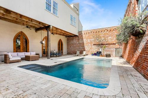 a swimming pool in a yard next to a brick building at Stunning 5 BR Urban Oasis Downtown NOLA in New Orleans