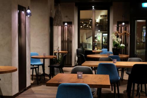un restaurante con mesas de madera y sillas azules en Hotel Jakob en Rapperswil-Jona