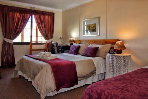 a hotel room with a large bed and a window at Zoete Inval in Hermanus