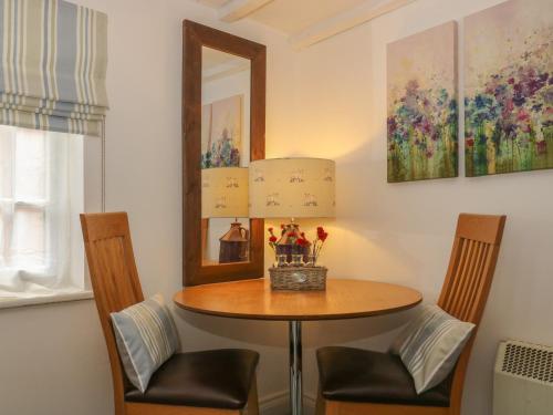 a dining room table with two chairs and a lamp at The Hideaway in York