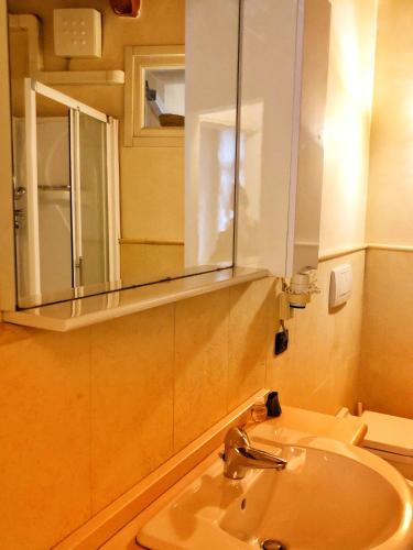uma casa de banho com um lavatório e um espelho em Terrazza Tassis Charme&Relax em Bérgamo