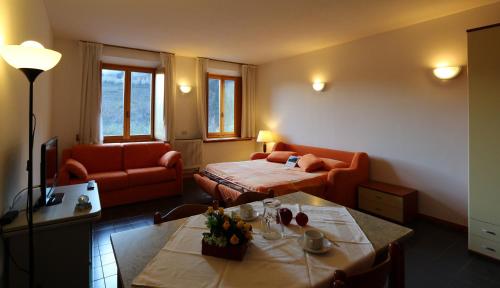 sala de estar con cama y sofá en Casa Pesarina, en Prato Carnico
