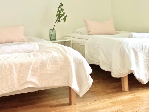 two beds with white sheets in a room at City Home Finland Tampella - City View, Own SAUNA, One Bedroom, Furnished Balcony and Great Location in Tampere