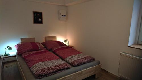 a bedroom with two beds with red blankets at Ferienwohnung Wäldle in Bad Sachsa