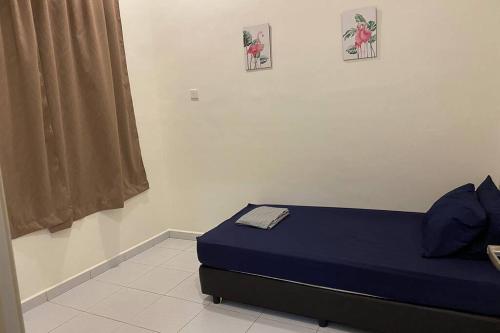 een slaapkamer met een blauw bed met twee foto's aan de muur bij Twilight Imani Homestay Changlun in Changlun