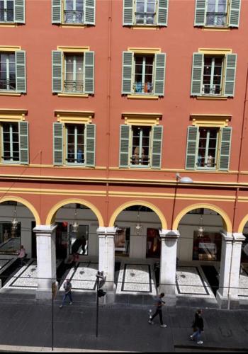a large orange building with people walking in front of it at Gustave 2 in Nice