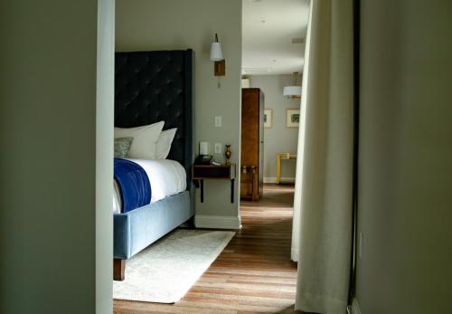 a bedroom with a bed with a blue bedspread at The Colonial Inn in Hillsborough